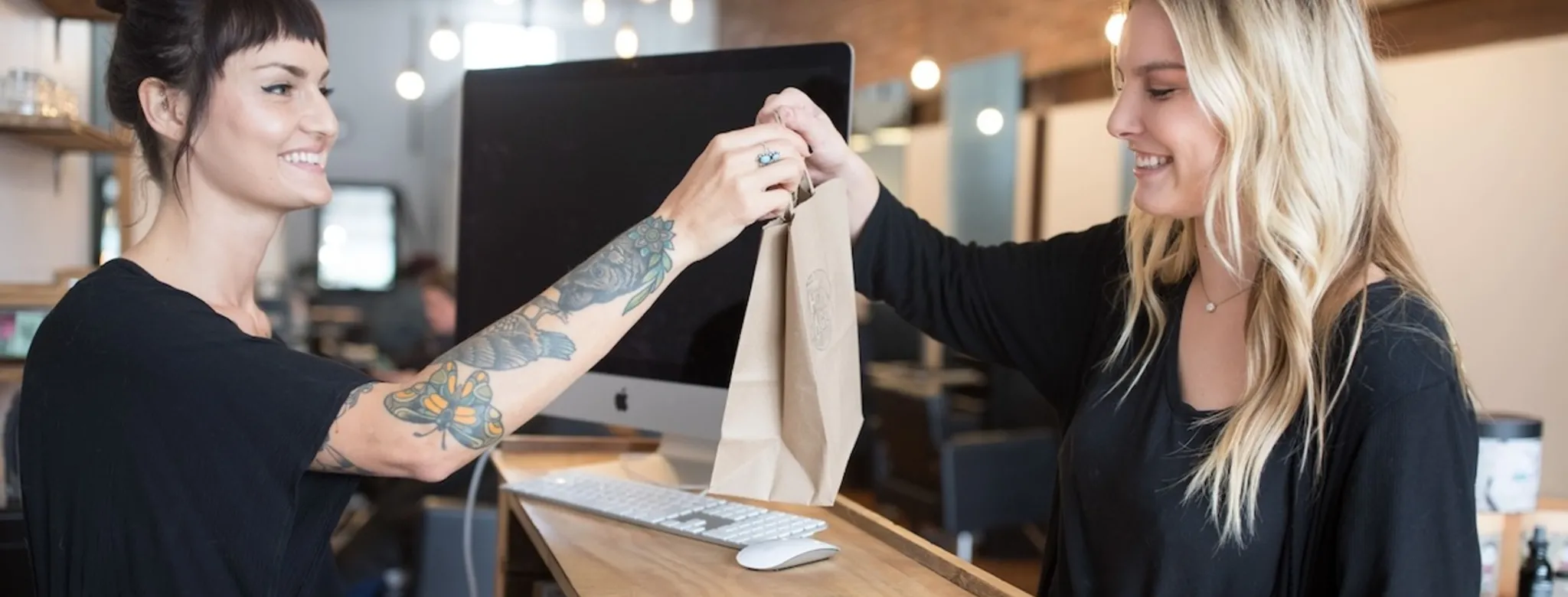 An employee checking a client out at a salon.