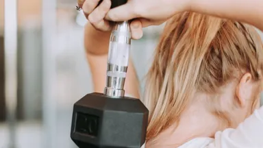 woman with blonde hair lift weight over her head