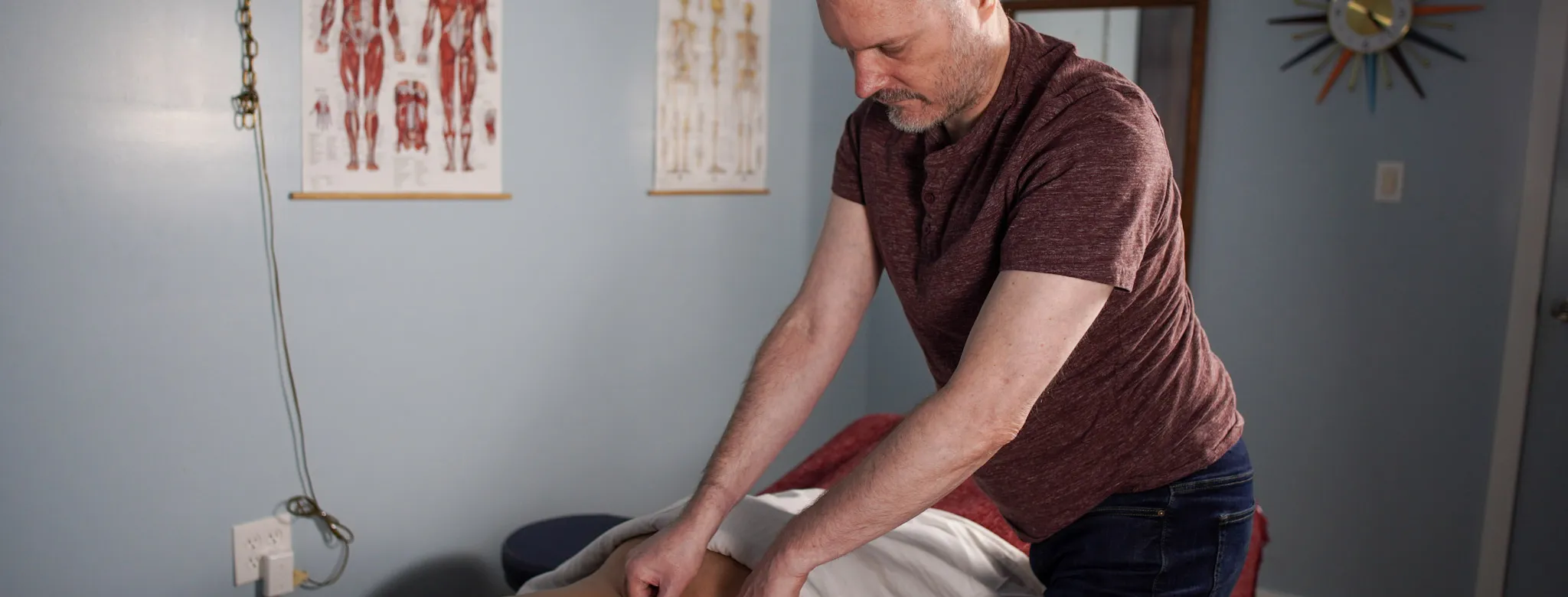 A man performing massage services on a client. 