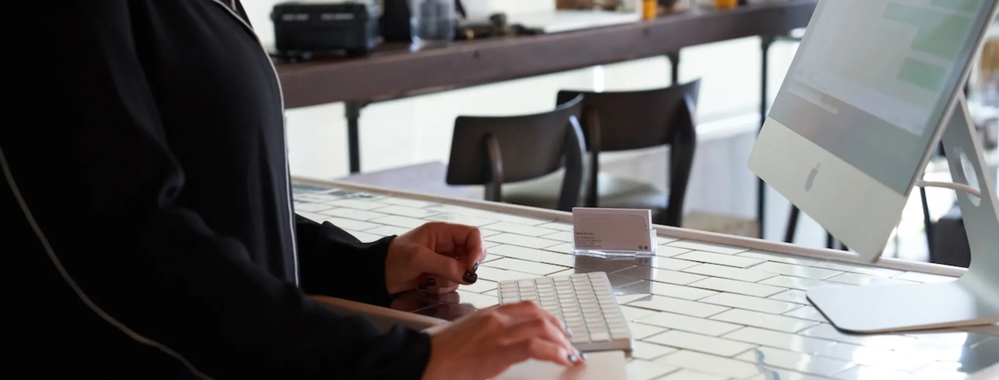 A woman using a computer at the front desk