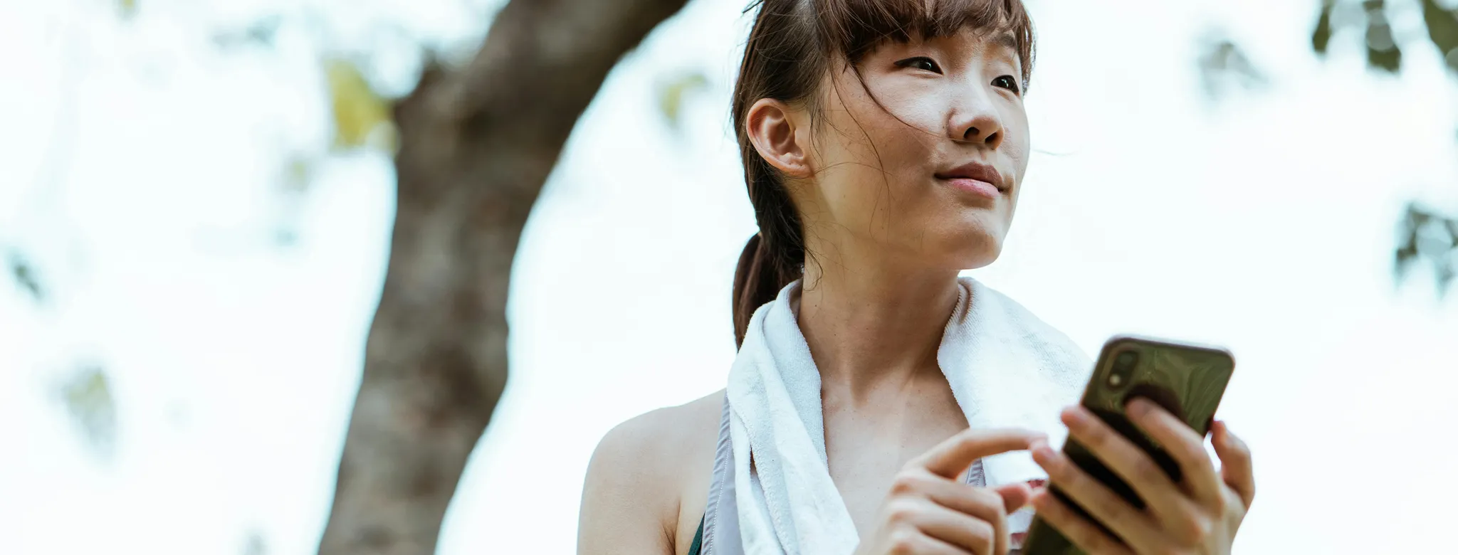 runner on phone outside reading about wellness trends