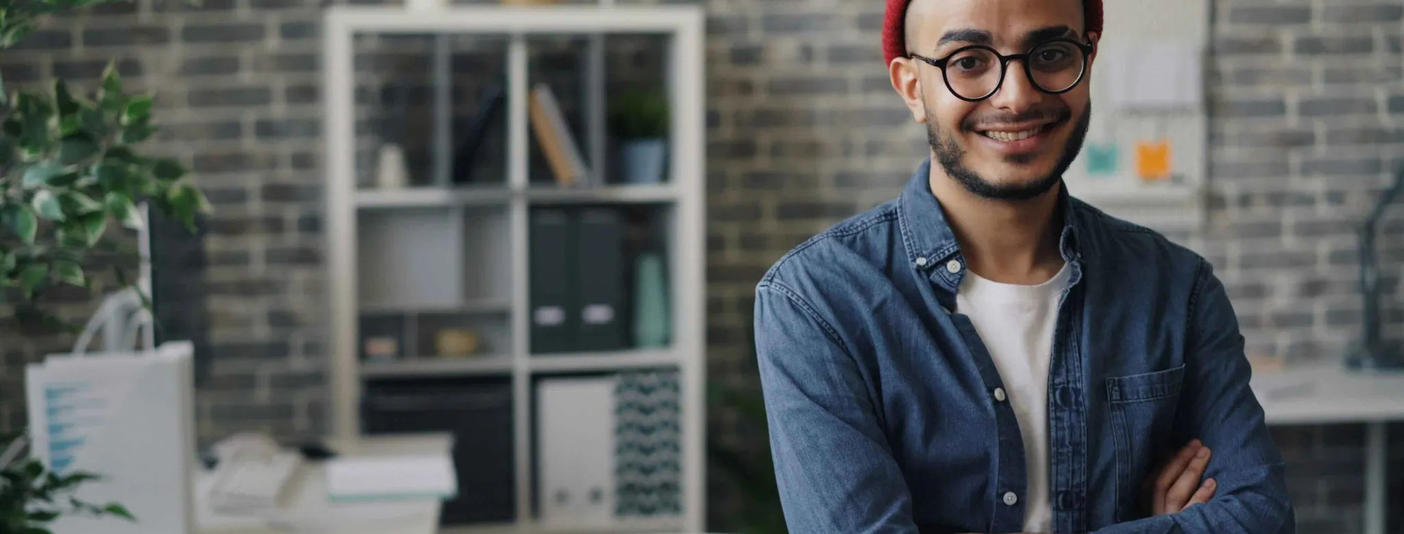Salon owner smiling in blue shirt and red hat