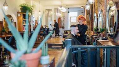 Stylist styling male client's hair