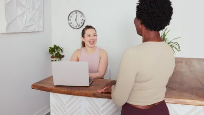 Two people having a conversation at a wellness business front desk