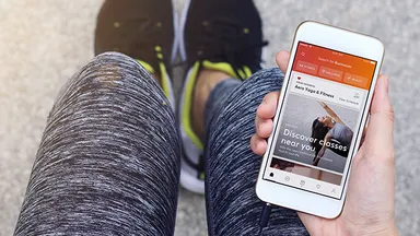 Person browsing Mindbody app on phone